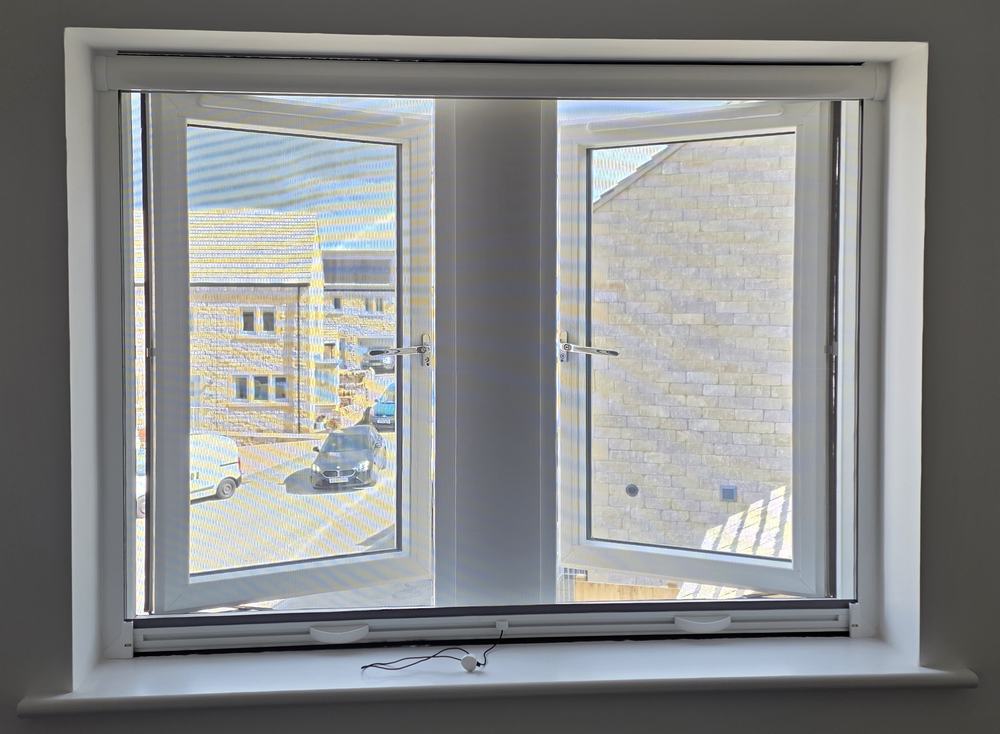 Roller fly screen fitted inside a window reveal
